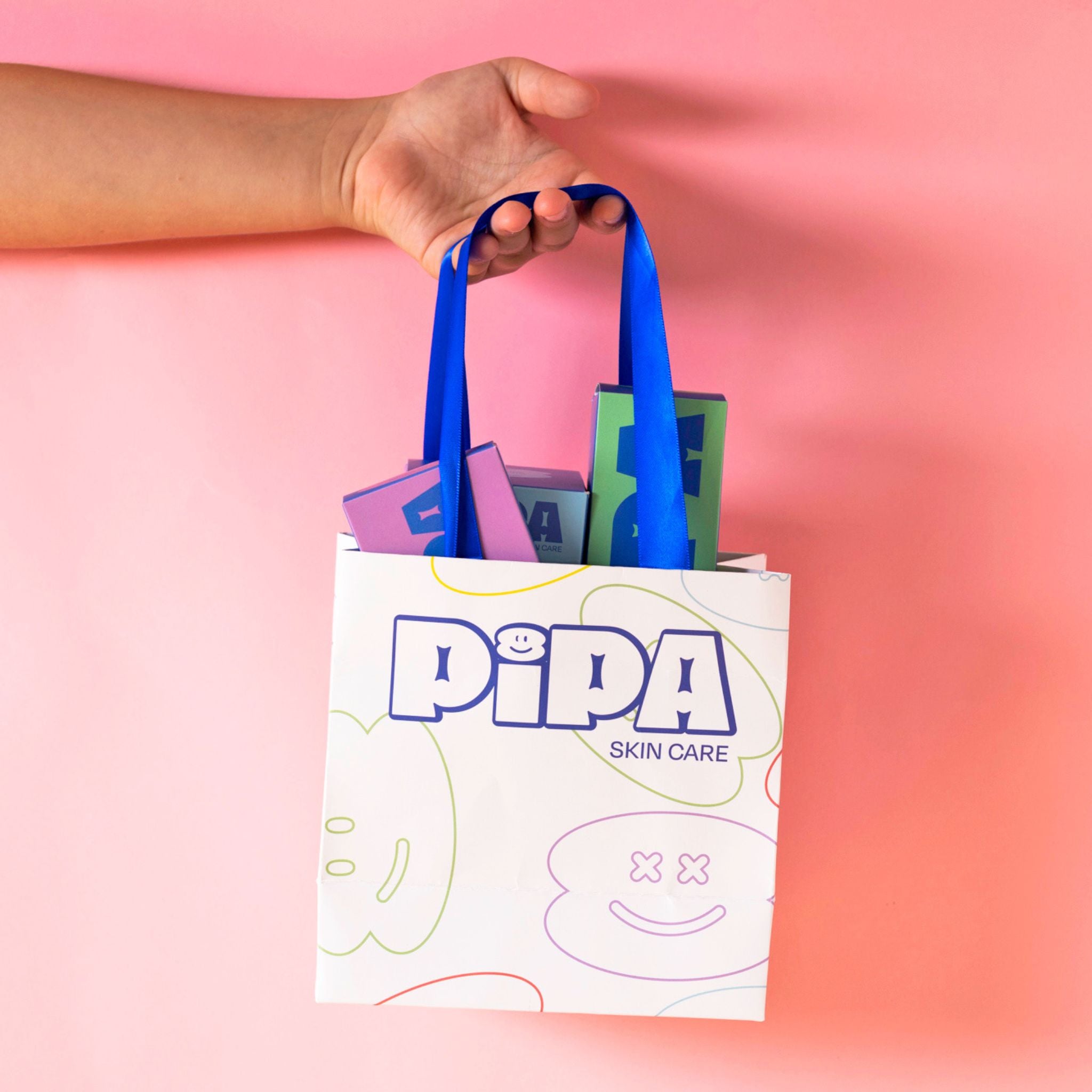 Pipa Gift Bag with ribbon handles on a pink background.