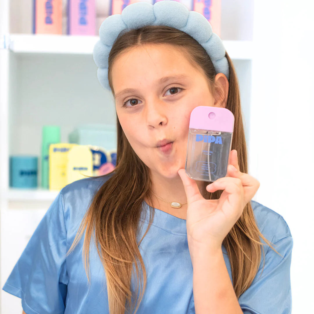 Tween holding Glow Go mist bottle, designed to refresh and hydrate young skin with safe ingredients.