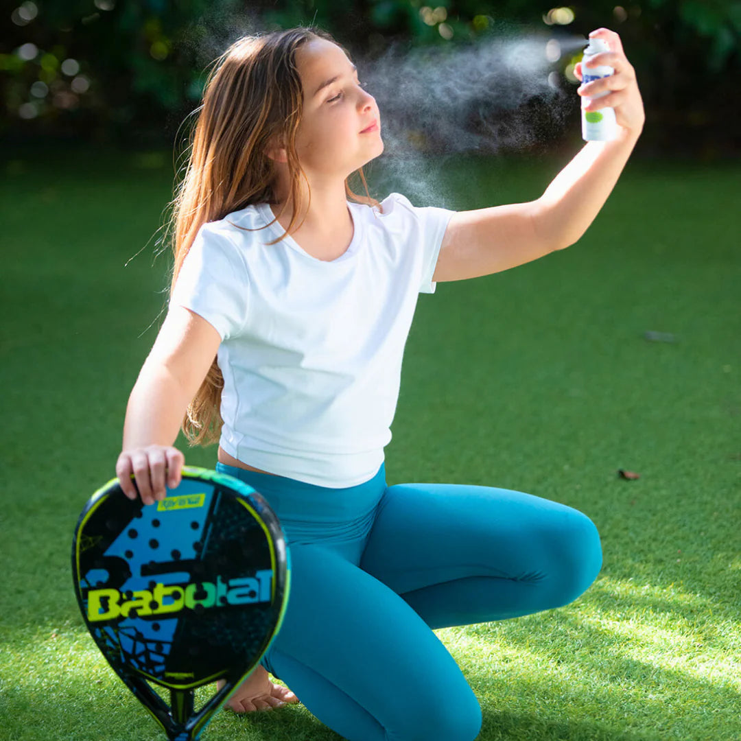 Girl using Skin Saver face and body spray outdoors on a sunny day.