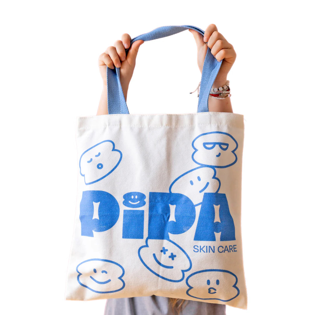 Pipa Tote bag with blue handles and playful face designs, perfect for eco-friendly shopping.