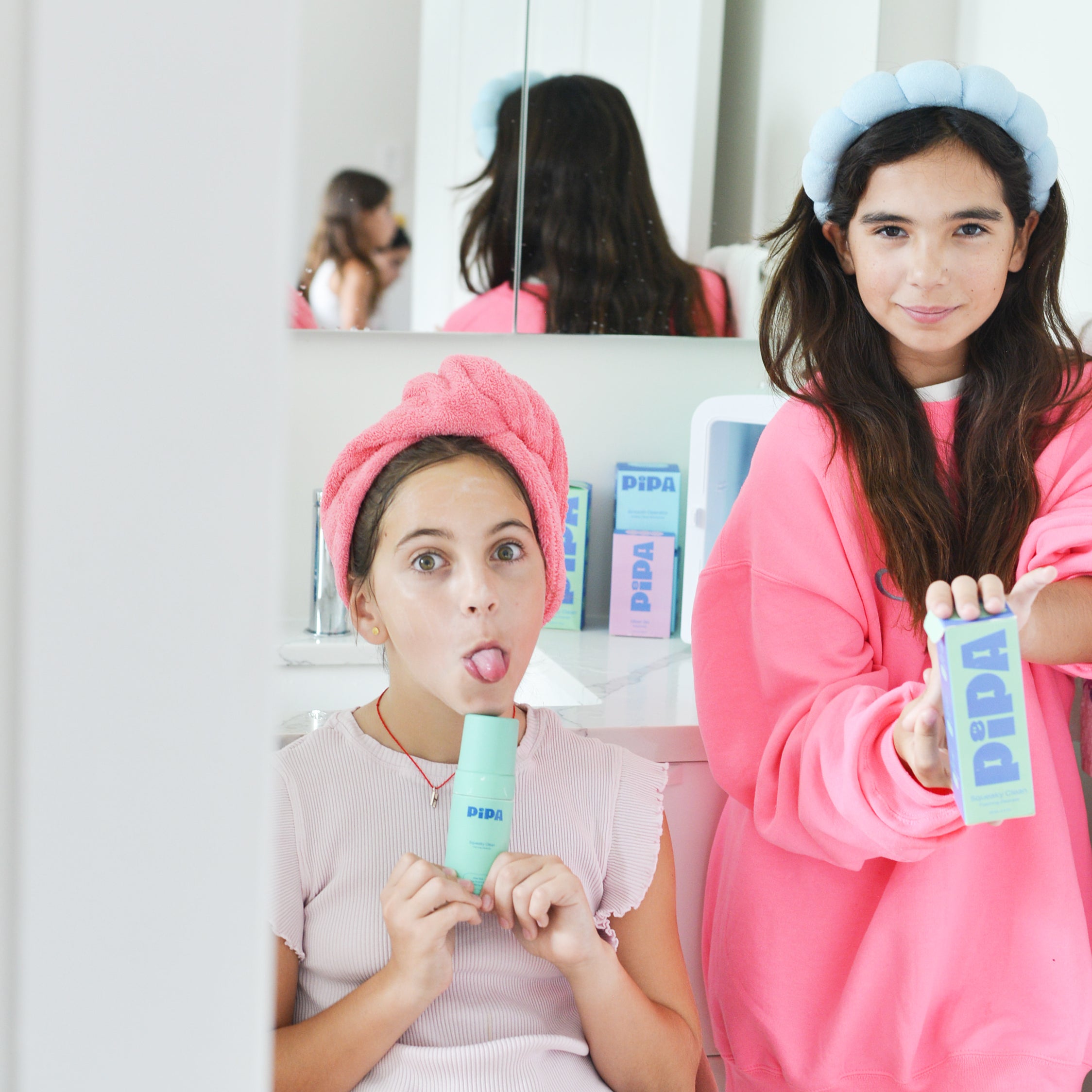 Two young girls using Squeaky Clean facial cleanser with aloe vera and papaya seed.