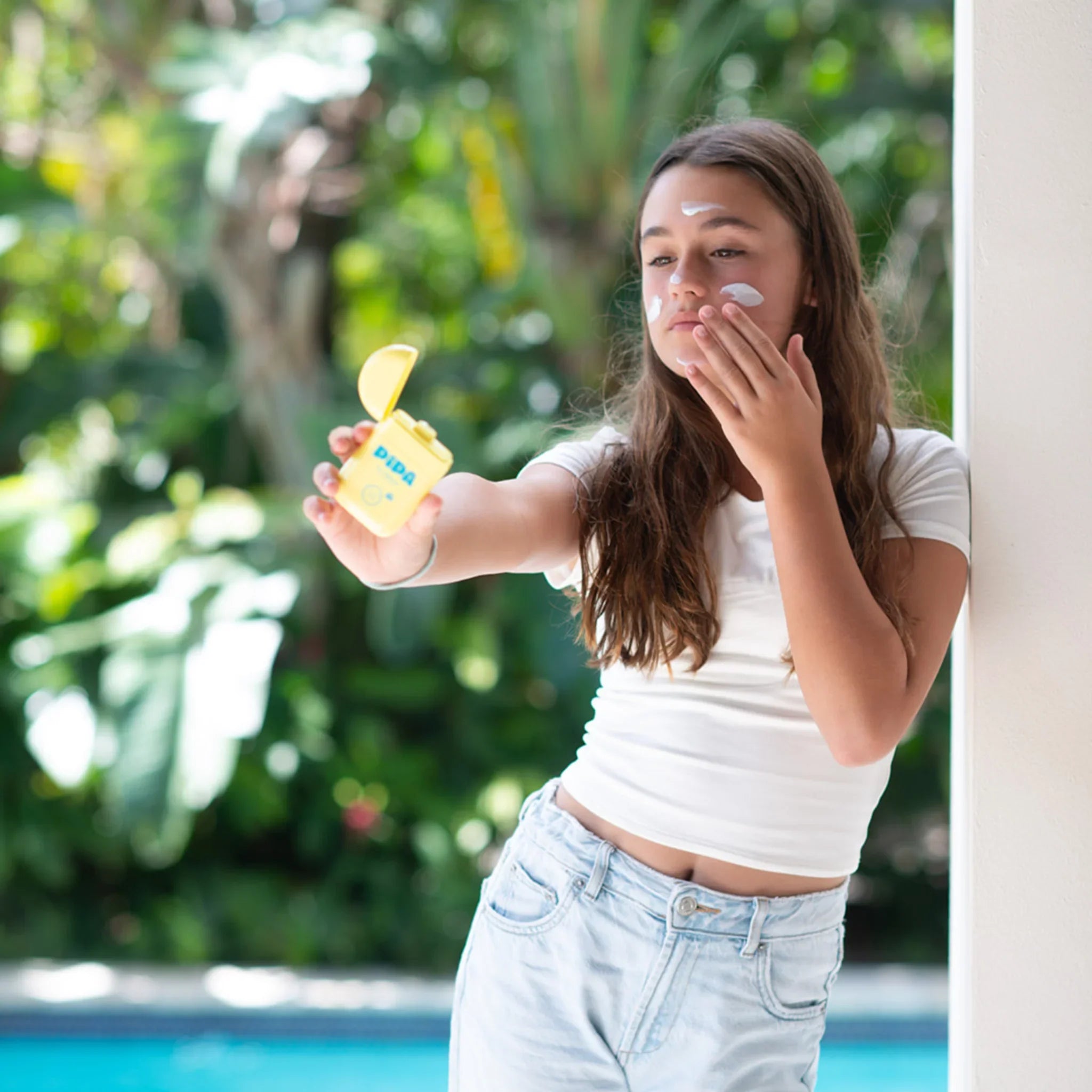 Tween girl using Sun-Sational mineral sunscreen outside